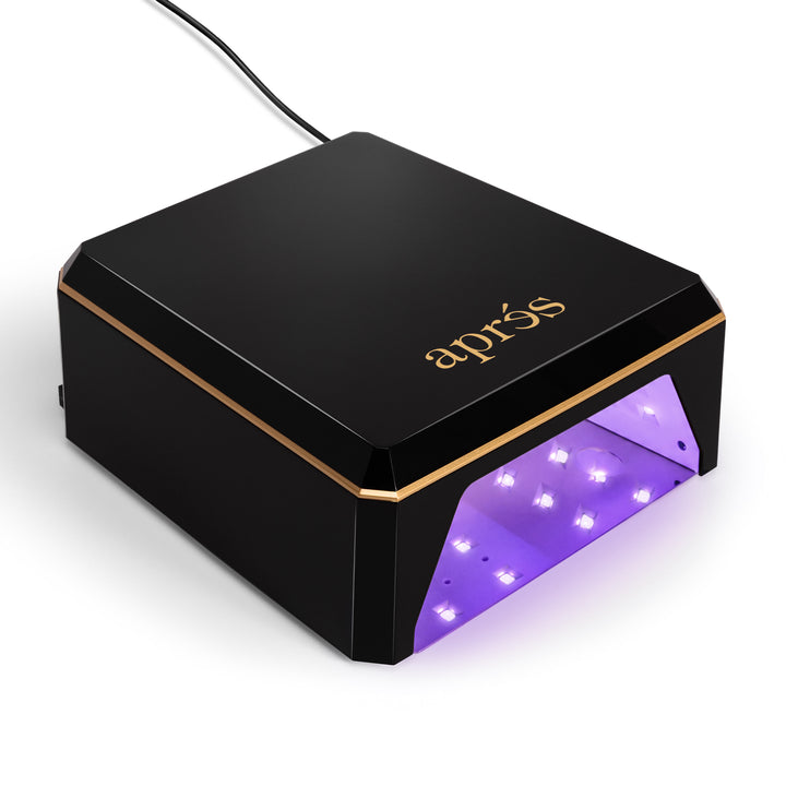 Aprés Mini Nova LED nail lamp in black, front view with the LEDs lit