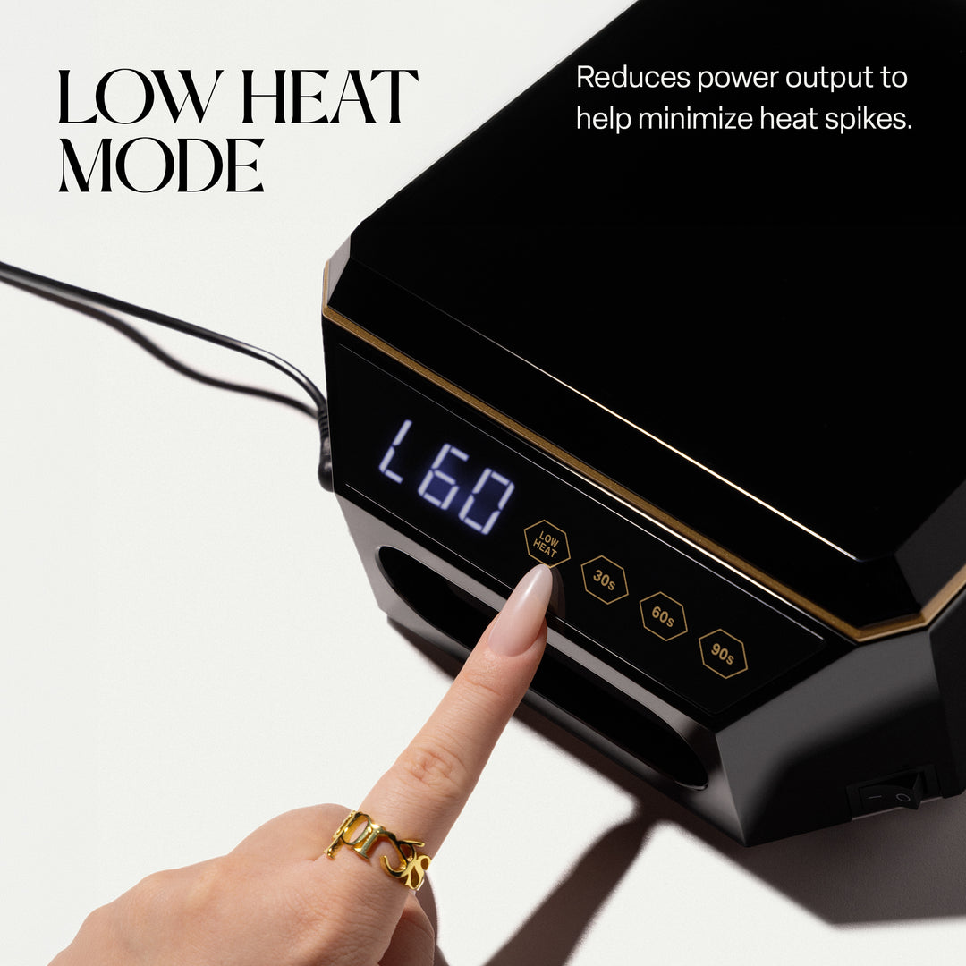 Finger pressing the LOW HEAT button on the Aprés Mini Nova black LED lamp, display showing L60