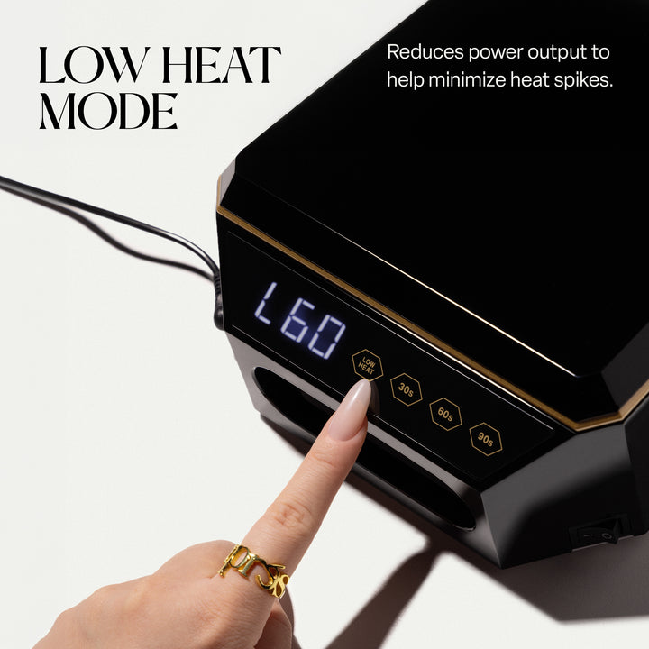 Finger pressing the LOW HEAT button on the Aprés Mini Nova black LED lamp, display showing L60